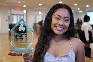 student during event posing with award